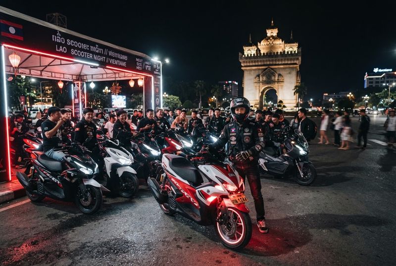 Riders gathered at a night event near Patuxai